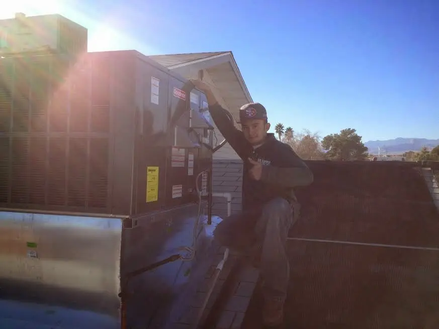 HVAC technician performing Air Duct Repair on a rooftop unit in Green